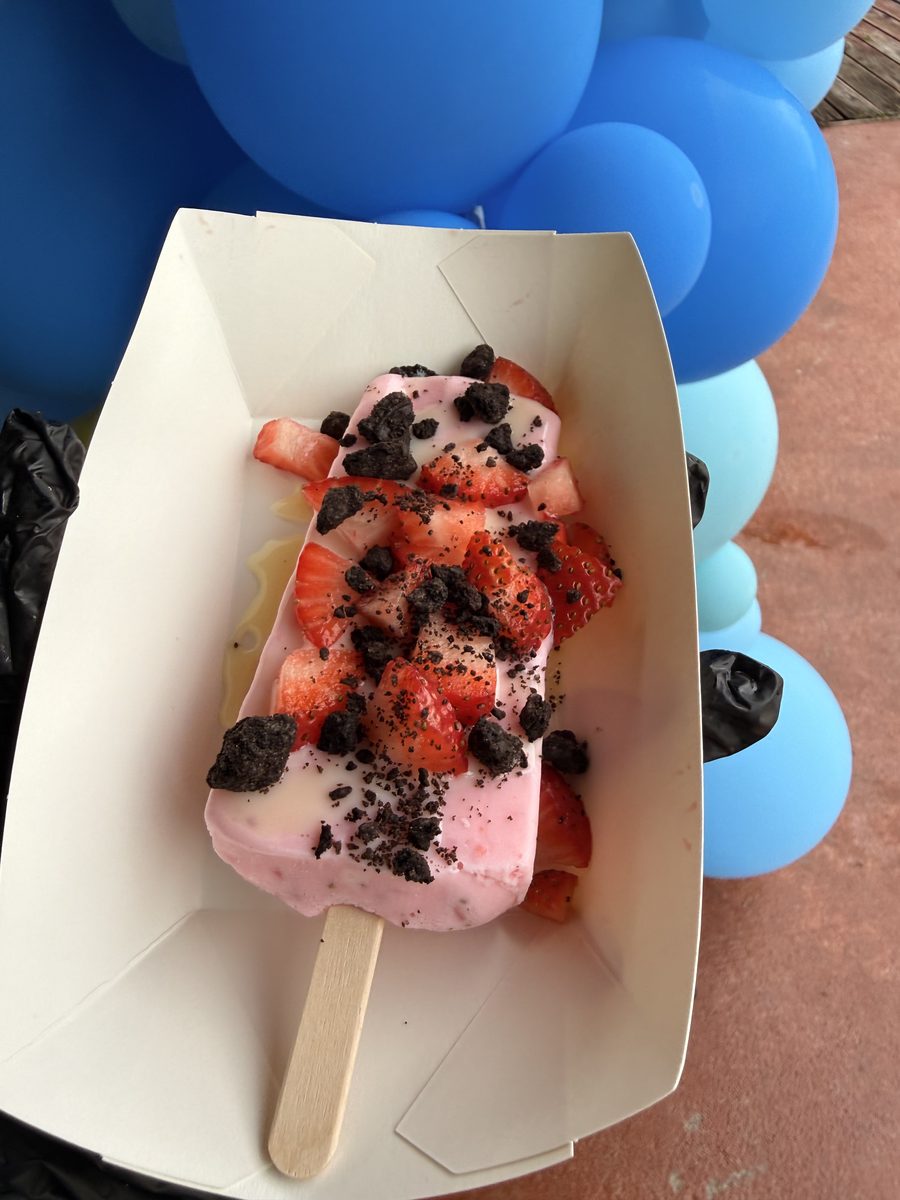 A strawberry paleta topped with fresh strawberries and cookie crumbs